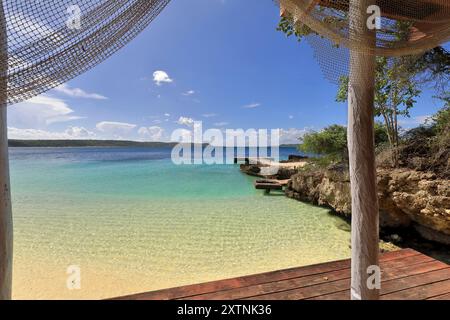 620 Holzdiele und Holzpfosten-Schuppen unter dem lokalen Strandrestaurant, alter Zementpier, der nach Westen auf die Westküste von Cayo Saetia Cay zeigt. Mayari-Kuba. Stockfoto