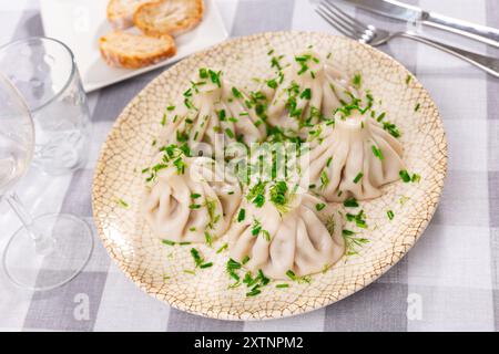 Auf dem Teller gibt es eine Portion Khinkali - ein nationales georgisches Gericht aus Teig und Fleisch Stockfoto