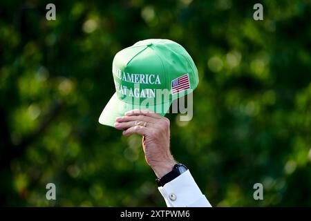 Bedminster, Usa. August 2024. Ein Teilnehmer hält einen Hut bei einer Pressekonferenz im Trump National Golf Club in Bedminster, New Jersey am Donnerstag, den 15. August 2024. Das Familienunternehmen des ehemaligen Präsidenten versucht, Wohnhäuser und Einzelhandelsgeschäfte im Trump National Doral Miami Resort zu bauen, wie Dokumente auf einer Website der Stadt Doral veröffentlicht wurden. Foto: Bing Guan/UPI Credit: UPI/Alamy Live News Stockfoto