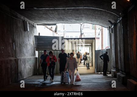 Bild von lettern, die in einem Tunnel unter einer Brücke im Stadtzentrum von Riga, Lettland, spazieren. Das Foto zeigt eine vielfältige Gruppe von p Stockfoto