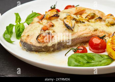 Köstliches gebackenes Lachssteak mit Sahnesauce und Muscheln wird auf einem Teller serviert und verzehrfertig serviert Stockfoto