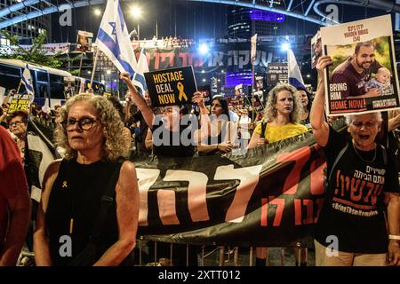 Israel. August 2024. Israelische Frauen singen, während sie Schilder mit dem Foto der israelischen Geisel Yarden Bibas und einem Schild mit der Aufschrift „Geiselhandel jetzt“ hochhalten. Die Israelis demonstrierten mit den Familien der Geiseln gegen Premierminister Benjamin Netanjahu und forderten ein sofortiges Geiselabkommen und einen Waffenstillstand - während in Katar Verhandlungen über den Waffenstillstand im Gazastreifen stattfinden. Tel Aviv, Israel. August 2024. (Matan Golan/SIPA USA). Quelle: SIPA USA/Alamy Live News Stockfoto