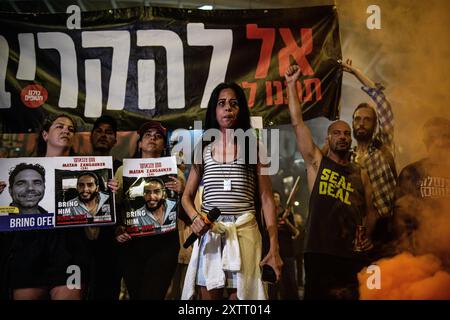 Israel. August 2024. Einav Zangauker, Mutter der israelischen Geisel Matan Zangauker, hält eine Rede, auf dem Schild auf der Rückseite steht: „Lass ihn sie nicht opfern!“ Die Israelis demonstrierten mit den Familien der Geiseln gegen Premierminister Benjamin Netanjahu und forderten ein sofortiges Geiselabkommen und einen Waffenstillstand - während in Katar Verhandlungen über den Waffenstillstand im Gazastreifen stattfinden. Tel Aviv, Israel. August 2024. (Matan Golan/SIPA USA). Quelle: SIPA USA/Alamy Live News Stockfoto