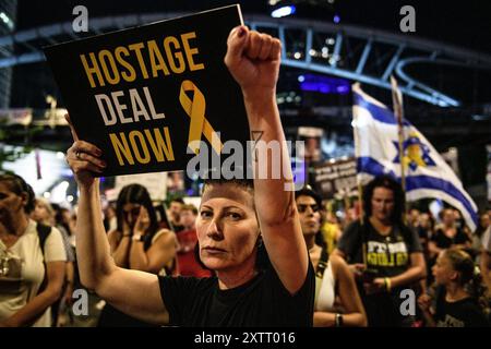Israel. August 2024. Eine Demonstrantin mit einem "Geiselvertrag jetzt"-Schild hält ihre Faust in die Luft. Die Israelis demonstrierten mit den Familien der Geiseln gegen Premierminister Benjamin Netanjahu und forderten ein sofortiges Geiselabkommen und einen Waffenstillstand - während in Katar Verhandlungen über den Waffenstillstand im Gazastreifen stattfinden. Tel Aviv, Israel. August 2024. (Matan Golan/SIPA USA). Quelle: SIPA USA/Alamy Live News Stockfoto