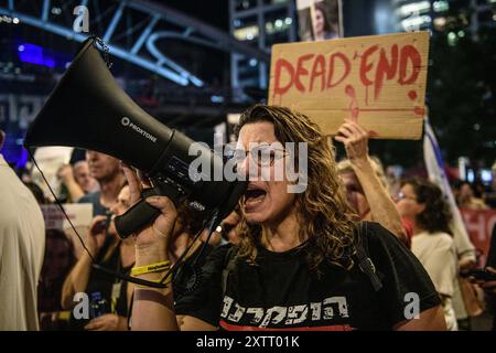 Israel. August 2024. Ein Demonstrant singt vor einem Schild mit der Aufschrift: "Sackgasse". Die Israelis demonstrierten mit den Familien der Geiseln gegen Premierminister Benjamin Netanjahu und forderten ein sofortiges Geiselabkommen und einen Waffenstillstand - während in Katar Verhandlungen über den Waffenstillstand im Gazastreifen stattfinden. Tel Aviv, Israel. August 2024. (Matan Golan/SIPA USA). Quelle: SIPA USA/Alamy Live News Stockfoto