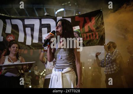 Israel. August 2024. Einav Zangauker, Mutter der israelischen Geisel Matan Zangauker, hält eine Rede, auf dem Schild auf der Rückseite steht: „Lass ihn sie nicht opfern!“ Die Israelis demonstrierten mit den Familien der Geiseln gegen Premierminister Benjamin Netanjahu und forderten ein sofortiges Geiselabkommen und einen Waffenstillstand - während in Katar Verhandlungen über den Waffenstillstand im Gazastreifen stattfinden. Tel Aviv, Israel. August 2024. (Matan Golan/SIPA USA). Quelle: SIPA USA/Alamy Live News Stockfoto