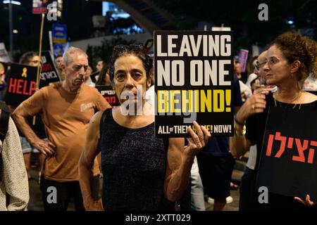 Israel. August 2024. Ein Demonstrant hält ein Schild mit der Aufschrift „Lassen Sie niemanden zurück! Alle sind jetzt zu Hause.“ Die Israelis demonstrierten mit den Familien der Geiseln gegen Premierminister Benjamin Netanjahu und forderten ein sofortiges Geiselabkommen und einen Waffenstillstand - während in Katar Verhandlungen über den Waffenstillstand im Gazastreifen stattfinden. Tel Aviv, Israel. August 2024. (Matan Golan/SIPA USA). Quelle: SIPA USA/Alamy Live News Stockfoto