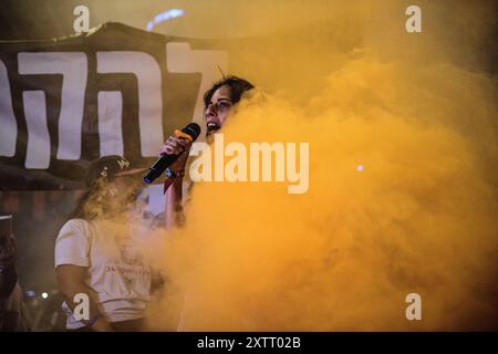 Israel. August 2024. Einav Zangauker, Mutter der israelischen Geisel Matan Zangauker, hält eine Rede, auf dem Schild auf der Rückseite steht: „Lass ihn sie nicht opfern!“ Die Israelis demonstrierten mit den Familien der Geiseln gegen Premierminister Benjamin Netanjahu und forderten ein sofortiges Geiselabkommen und einen Waffenstillstand - während in Katar Verhandlungen über den Waffenstillstand im Gazastreifen stattfinden. Tel Aviv, Israel. August 2024. (Matan Golan/SIPA USA). Quelle: SIPA USA/Alamy Live News Stockfoto