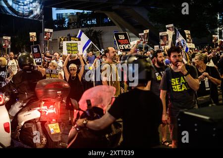 Israel. August 2024. Demonstranten blockieren die Straße, während sie Schilder mit den Fotos der israelischen Geiseln hochhalten, auf denen steht: „Seal the Deal“. Die Israelis demonstrierten mit den Familien der Geiseln gegen Premierminister Benjamin Netanjahu und forderten ein sofortiges Geiselabkommen und einen Waffenstillstand - während in Katar Verhandlungen über den Waffenstillstand im Gazastreifen stattfinden. Tel Aviv, Israel. August 2024. (Matan Golan/SIPA USA). Quelle: SIPA USA/Alamy Live News Stockfoto