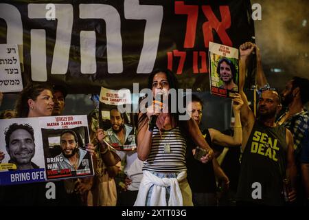 Israel. August 2024. Einav Zangauker, Mutter der israelischen Geisel Matan Zangauker, hält eine Rede, auf dem Schild auf der Rückseite steht: „Lass ihn sie nicht opfern!“ Die Israelis demonstrierten mit den Familien der Geiseln gegen Premierminister Benjamin Netanjahu und forderten ein sofortiges Geiselabkommen und einen Waffenstillstand - während in Katar Verhandlungen über den Waffenstillstand im Gazastreifen stattfinden. Tel Aviv, Israel. August 2024. (Matan Golan/SIPA USA). Quelle: SIPA USA/Alamy Live News Stockfoto