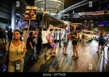 Tel Aviv, Israel. August 2024. Demonstranten blockieren die Straße, während sie Zeichen für einen Geiselvertrag halten. Die Israelis demonstrierten mit den Familien der Geiseln gegen Premierminister Benjamin Netanjahu und forderten ein sofortiges Geiselabkommen und einen Waffenstillstand - während in Katar Verhandlungen über den Waffenstillstand im Gazastreifen stattfinden. Israelis und die Familien der Geiseln demonstrierten gegen Premierminister Benjamin Netanjahu und forderten ein sofortiges Geiselabkommen und einen Waffenstillstand - während in Katar Verhandlungen über den Waffenstillstand im Gazastreifen stattfinden. Quelle: SOPA Images Limited/Alamy Live News Stockfoto