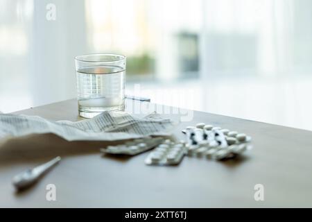 Pillen, ärztliche Verschreibung und medizinisches Thermometer auf dem Tisch vor dem Hintergrund des Fensters.für Themen rund um Medizin, häusliche Behandlung Stockfoto