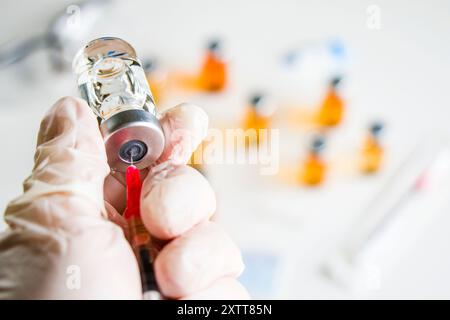 Mpox neuer Impfstoff in Ampullen und Flaschen, Nadel und Arzthänden mit Handschuh. Stockfoto