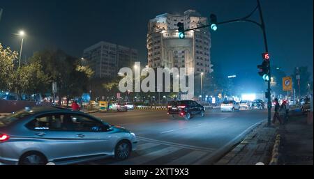 Neu-Delhi, Delhi, Indien. Verkehr auf der Connaught Lane, Barakhamba Street. Autos, Motorräder, Busse, Auto Rikscha oder Tuk-Tuk, die nachts auf der Straße unterwegs sind Stockfoto