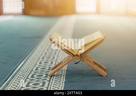 Der Heilige Koran: Das heilige Buch der Muslime, wunderschön in einer Moschee mit arabischer Kalligraphie ausgestellt. Es spiegelt die tiefe spirituelle Bedeutung wider Stockfoto