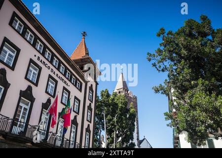 Banco da Madeira (Bank von Madeira) neben dem Glockenturm der Kathedrale von Funchal, die am 6. August 2024 auf Madeira gesehen wurde. Stockfoto