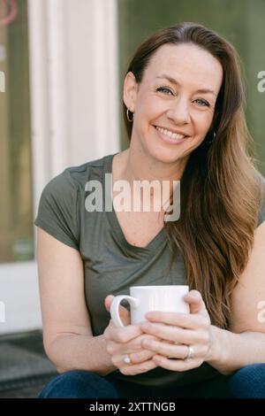 Weibliches solo-Porträt mit Kaffeetasse Stockfoto