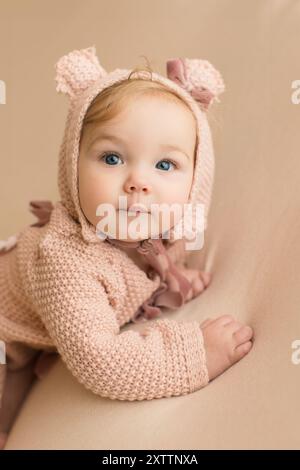 Blauäugiges Mädchen in einer rosa Bärenhaube Stockfoto