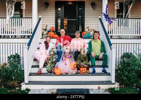 Familie in Halloween-Kostümen auf einer dekorierten Veranda Stockfoto