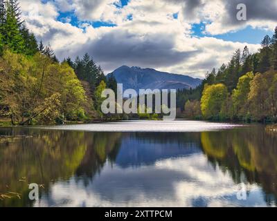 Der Blick auf Glencoe Lochan mit seinen üppigen Wäldern und lebhaften Farben spiegelt sich im kristallklaren Wasser wider Stockfoto