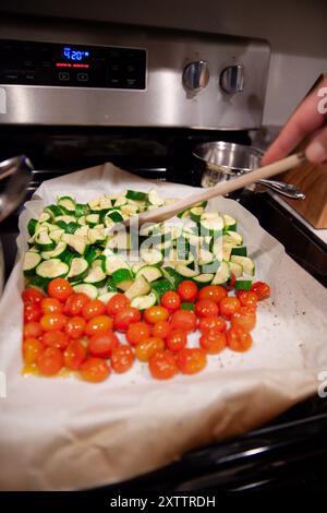 Holzlöffel zum Rühren von geröstetem Gemüse auf einem Backblech Stockfoto