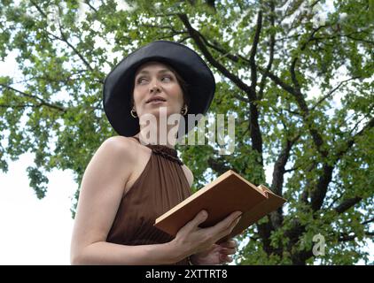 Eine junge Frau mit Zahnspangen hält ein offenes Buch in den Händen Stockfoto