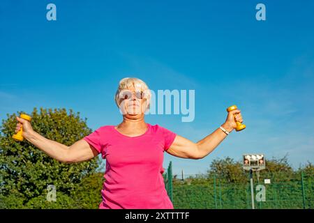 Ältere Frau, die mit Kurzhanteln trainiert Stockfoto