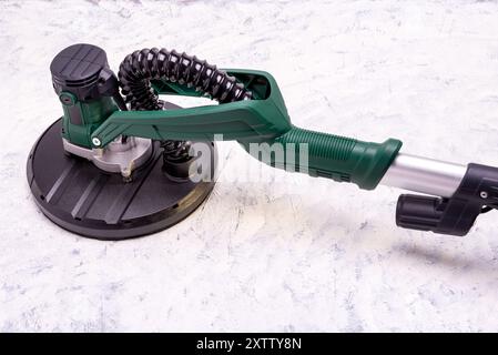 Wandschleifer mit Teleskopgriff und LED-Licht zum Glätten und Schleifen von Wänden auf grauweißem Hintergrund. Stockfoto