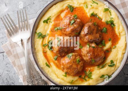 Klassische italienische Fleischbällchen mit cremiger Polenta-Nahaufnahme auf der Schüssel auf dem Tisch. Horizontale Draufsicht von oben Stockfoto