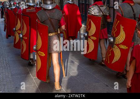 Römische Legionäre mit Metallpanzerung und Schild bei einer historischen Nachstellung von hinten gesehen. Stockfoto