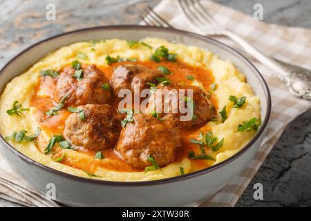 Frittierte Fleischbällchen mit scharfer Soße und Maispolenta in einer Schüssel auf dem Tisch. Horizontal Stockfoto