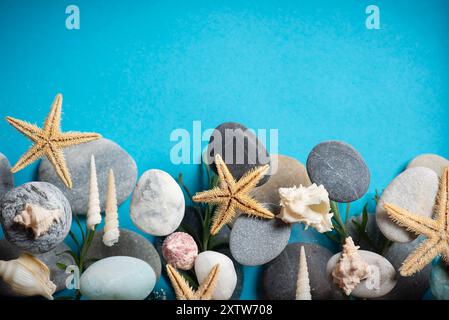 Abstrakter Hintergrund mit kleinen Steinen verschiedener Formen, Farben und Größen, Muscheln und Sterne auf einem blauen Hintergrund in Nahaufnahme. Mit Kopierraum Stockfoto
