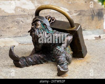 Wrocław, Polen – September 2022: Zwerg mit Vorhängeschloss in der Nähe der Brücke. Kleine bronzene Figuren von Gnomen auf den Straßen von Breslau. Europa Stockfoto