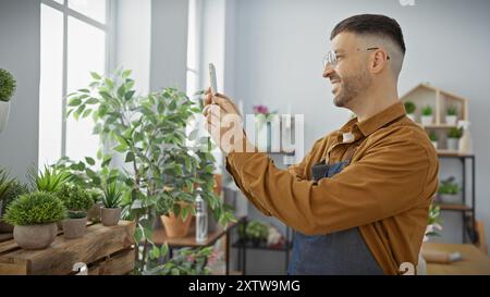Hispanischer Mann mit Bart, der im Blumenladen fotografiert und eine moderne Pflanzenmarktszene darstellt. Stockfoto