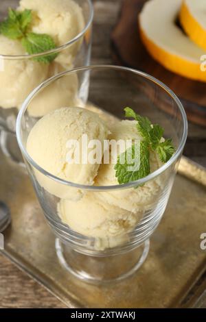 Löffel Melonensorbet und Minze in Dessertschalen aus Glas auf dem Tisch, Nahaufnahme Stockfoto