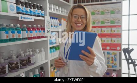 Lächelnde Apothekerin mit Tablette im modernen Drogeriemarkt Stockfoto