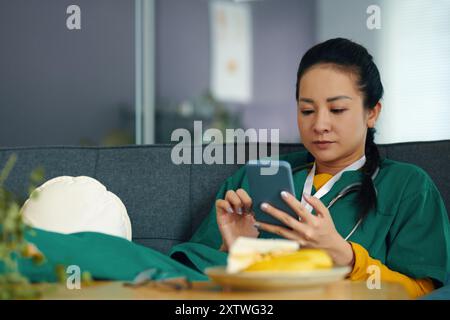 Lesen von Nachrichten auf dem Smartphone während der Mittagspause Stockfoto