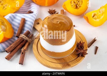 Kürbis-Gewürz-Dalgona-Kaffee-Cocktail, süßer, leckerer Herbstlatte mit Pumokinpüree, Schlagsahne und Schlagsahne-Instant-Dalgona-Kaffeeschaum Stockfoto