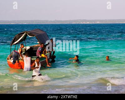 Sansibar, Tansania - Jan, 2021: Boot mit einer Gruppe afrikanischer Männer, die auf Prison Island (auch bekannt als Changuu, Quarantine Island i Kibandiko) festmachen. Heute Stockfoto