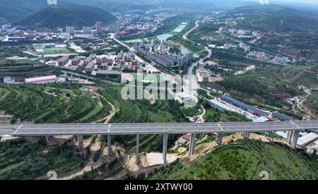 (240816) -- YINCHUAN, 16. August 2024 (Xinhua) -- dieses am 16. August 2024 aufgenommene Luftdrohnenfoto zeigt ein Fahrzeug, das entlang der Yinchuan-Kunming-Autobahn fährt, mit dem Kreis Pengyang im Hintergrund in der autonomen Region Ningxia Hui im Nordwesten Chinas. Ein Abschnitt der Yinchuan-Kunming-Autobahn innerhalb von Ningxia, von der Entwicklungszone Taiyangshan nach Pengyang, wurde fertiggestellt und am Freitag für den Verkehr freigegeben, was die vollständige Eröffnung der Yinchuan-Kunming-Autobahn markiert. Die Autobahn verbindet Yinchuan in der autonomen Region Ningxia Hui im Nordwesten Chinas mit Kunming in der Provinz Yunnan im Südwesten Chinas und erstreckt sich über 2322 Stockfoto