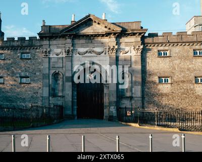 Der imposante Eingang einer historischen Steinfestung zeigt raffinierte architektonische Details und robuste Holztüren. Das Sonnenlicht wirft Schatten auf den Th Stockfoto