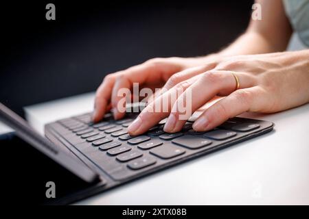 Berlin, Deutschland. August 2024. Hände tippen auf einem Tablet mit Tastatur in Berlin, 9. August 2024. || Modellveröffentlichung verfügbar Guthaben: dpa/Alamy Live News Stockfoto