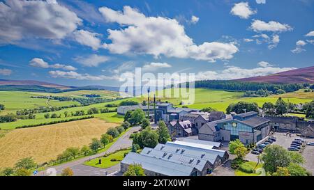 Glenlivet Destillerie Moray Scotland ein blauer Sommerhimmel über Gebäuden Lagerhäusern und den purolenheitsheidekrauten Hügeln Stockfoto