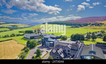 Die Glenlivet Destillerie Moray Scotland ein blauer Sommerhimmel über Gebäuden, Lagerhäusern und den mit Heidekraut bedeckten Hügeln Stockfoto