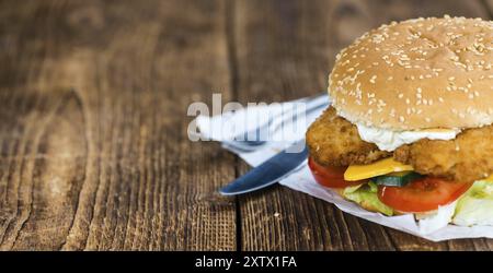 Holztisch mit frisch zubereitetem Fisch Burger (Nahaufnahme, selektiver Fokus) Stockfoto