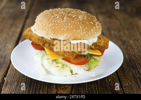 Holztisch mit frisch zubereitetem Fisch Burger (Nahaufnahme, selektiver Fokus) Stockfoto