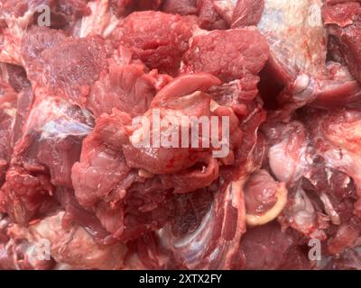 Ein Haufen rohes Fleisch mit blutig roter Farbe. Das Fleisch wird in kleine Stücke geschnitten und kann gekocht werden Stockfoto