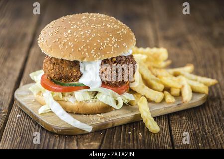 Hausgemachter Falafel Burger (detaillierte Nahaufnahme, selektiver Fokus) auf einem Holztisch Stockfoto