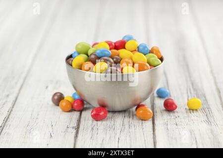 Cocolate beschichtet Erdnüsse auf rustikalen Holzmöbeln Hintergrund (Nahaufnahme) Stockfoto