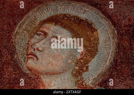 Das Gesicht des Heiligen Johannes des Evangelisten. Detail eines Kreuzigungsfreskos von 1300 im Bozner Dom oder Dom Maria Assunta (Marienkathedrale Himmelfahrt) in Bozen, Südtirol, Trentino-Südtirol, Italien. Das Fresko an der nördlichen Außenwand des Domturms gilt als das älteste Gemälde in Bozen. Stockfoto